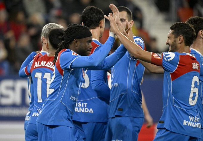 Atletico Madrid's forward #22 Ademola Lookman celebrates with teammates scoring his team's first goal from the penalty spot during the Spanish league football match between CA Osasuna and Club Atletico de Madrid at El Sadar Stadium in Pamplona on May 12, 2026